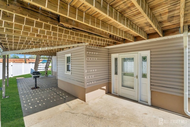 entrance to property with fence and a patio area