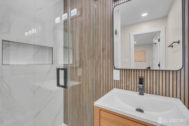 full bathroom with a shower stall and vanity