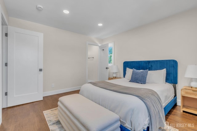 bedroom featuring wood finished floors, recessed lighting, and baseboards