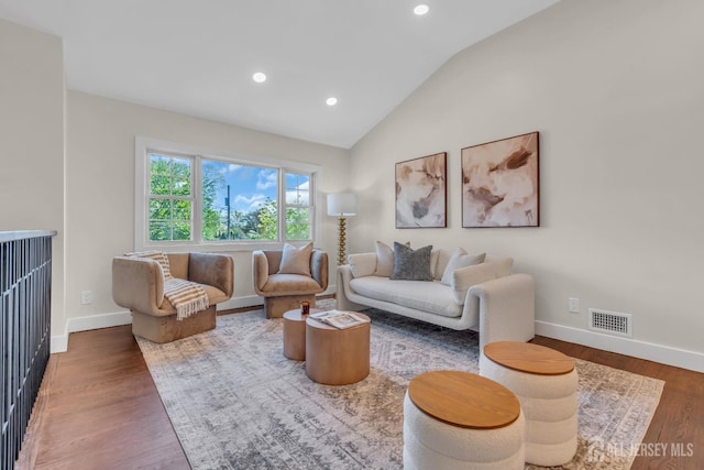 living area featuring vaulted ceiling, baseboards, wood finished floors, and recessed lighting