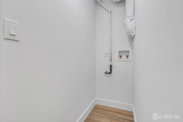 laundry area with washer hookup, baseboards, and light wood finished floors
