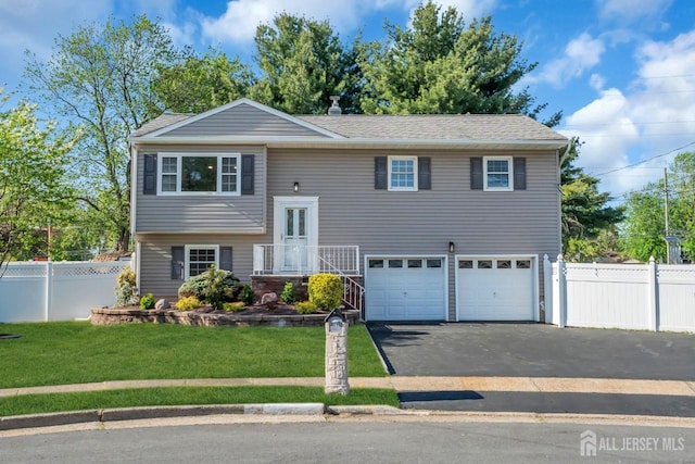 raised ranch with driveway and a garage