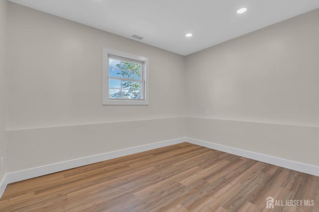 spare room featuring baseboards, light wood-type flooring, and recessed lighting