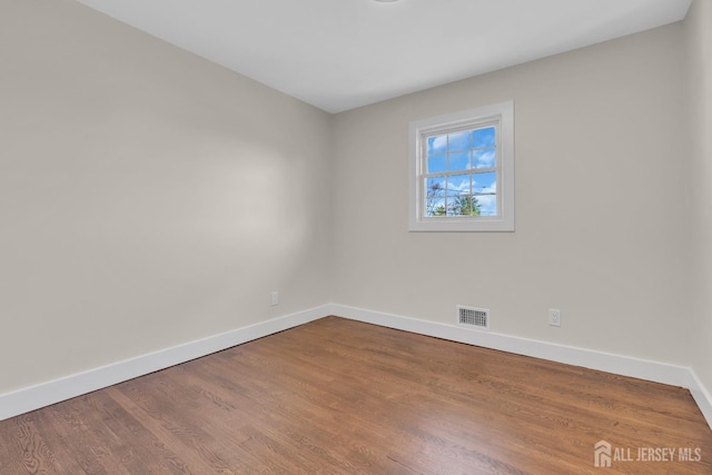 unfurnished room featuring baseboards and wood finished floors