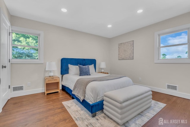 bedroom featuring baseboards, wood finished floors, and recessed lighting