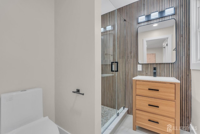 full bath featuring a shower stall, vanity, baseboards, and toilet