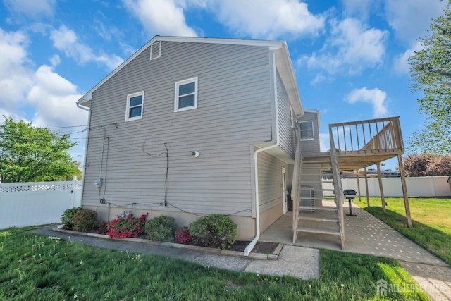view of property exterior with a wooden deck, a patio area, and stairway