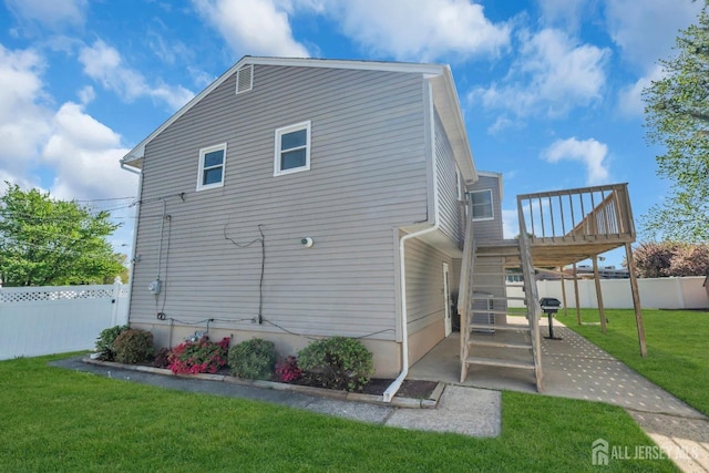 rear view of property featuring a wooden deck, a patio area, and stairs