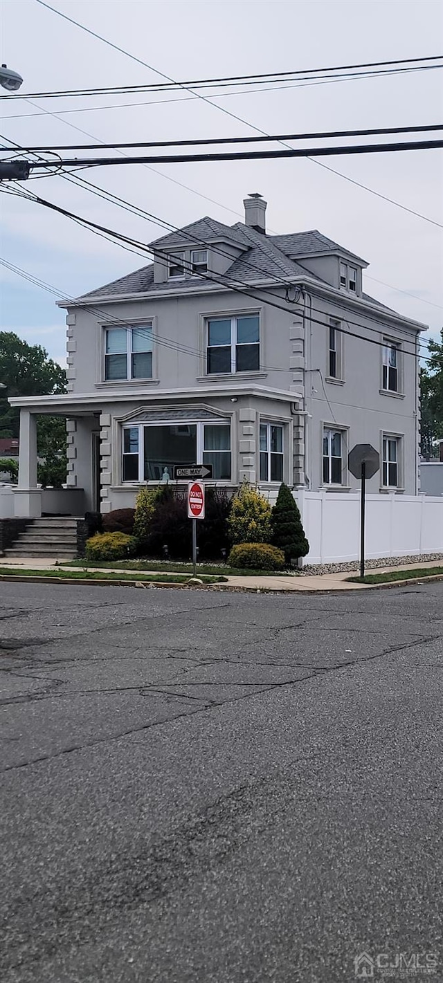 view of front of property with fence and stucco siding