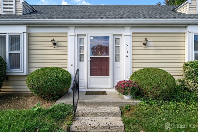 entrance to property with roof with shingles