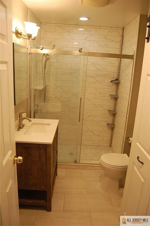 bathroom featuring vanity, tile patterned flooring, toilet, recessed lighting, and a stall shower