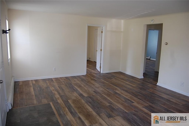 unfurnished room with baseboard heating, baseboards, wood finished floors, and a baseboard radiator