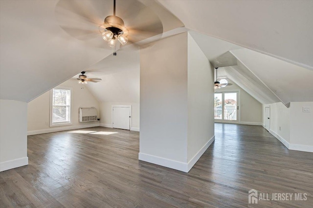 bonus room with a healthy amount of sunlight, vaulted ceiling, and dark hardwood / wood-style flooring