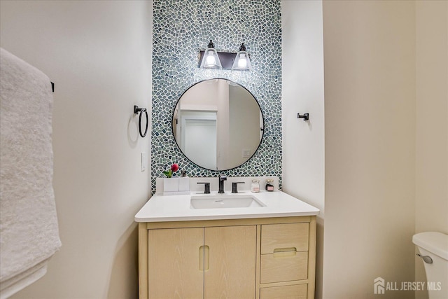 bathroom with toilet, tasteful backsplash, and vanity