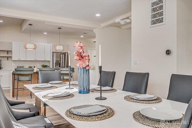 dining space featuring vaulted ceiling with beams