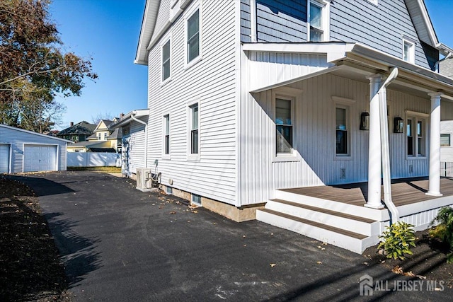 view of home's exterior with an outdoor structure, a porch, and a garage