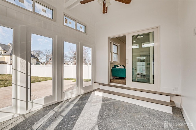 unfurnished sunroom featuring ceiling fan