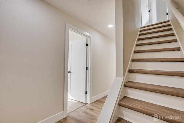 stairway with hardwood / wood-style floors