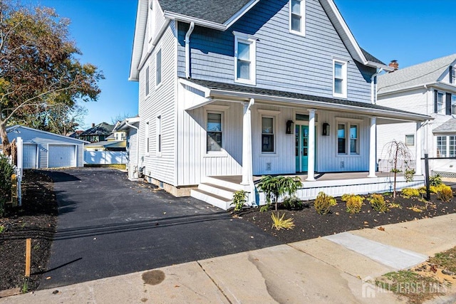 view of front of home featuring an outbuilding, a porch, and a garage