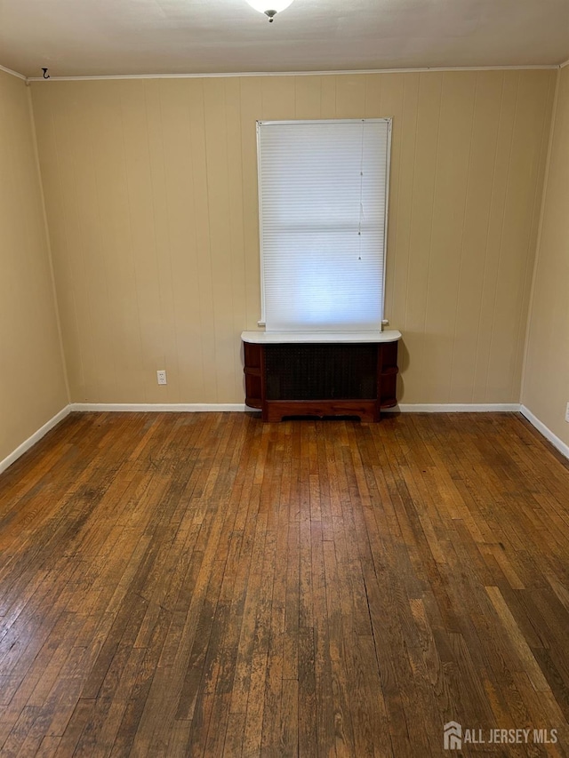 empty room with baseboards and hardwood / wood-style flooring