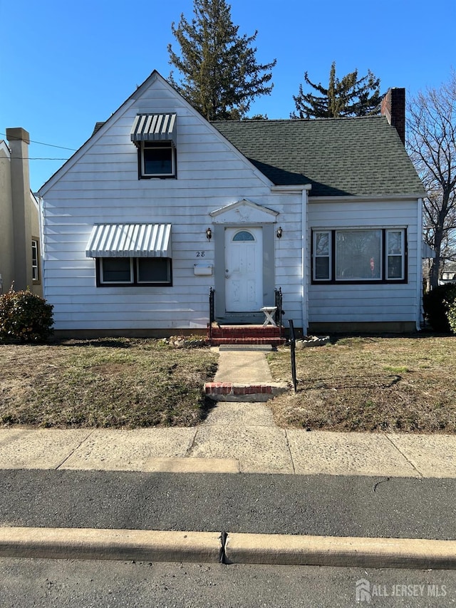 view of front of house featuring roof with shingles and a chimney