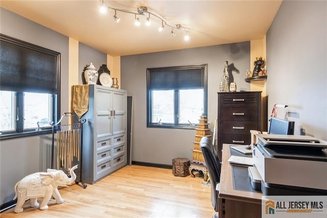 office area with track lighting, light wood finished floors, and plenty of natural light
