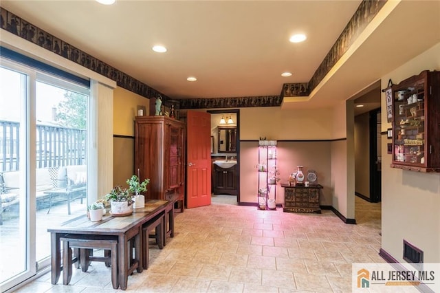 hallway with baseboards, visible vents, and recessed lighting