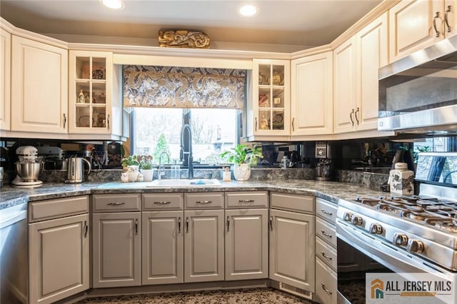 kitchen with recessed lighting, glass insert cabinets, gray cabinetry, appliances with stainless steel finishes, and a sink