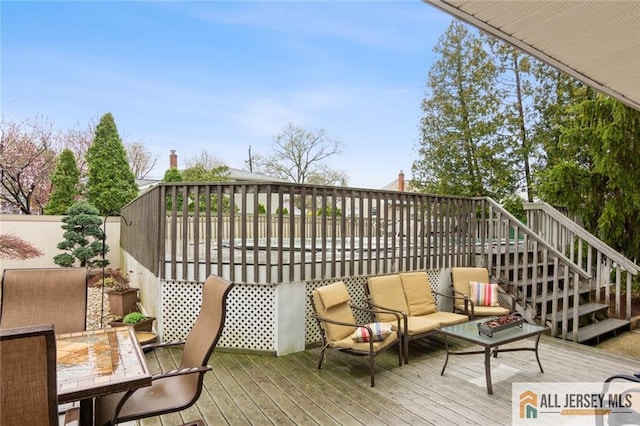 view of wooden balcony with outdoor dining space, stairway, a deck, and an outdoor hangout area