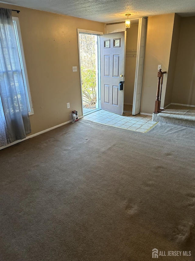 carpeted entrance foyer with a textured ceiling