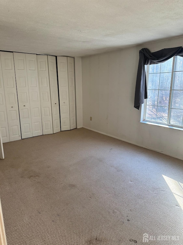 unfurnished bedroom featuring carpet flooring and a textured ceiling