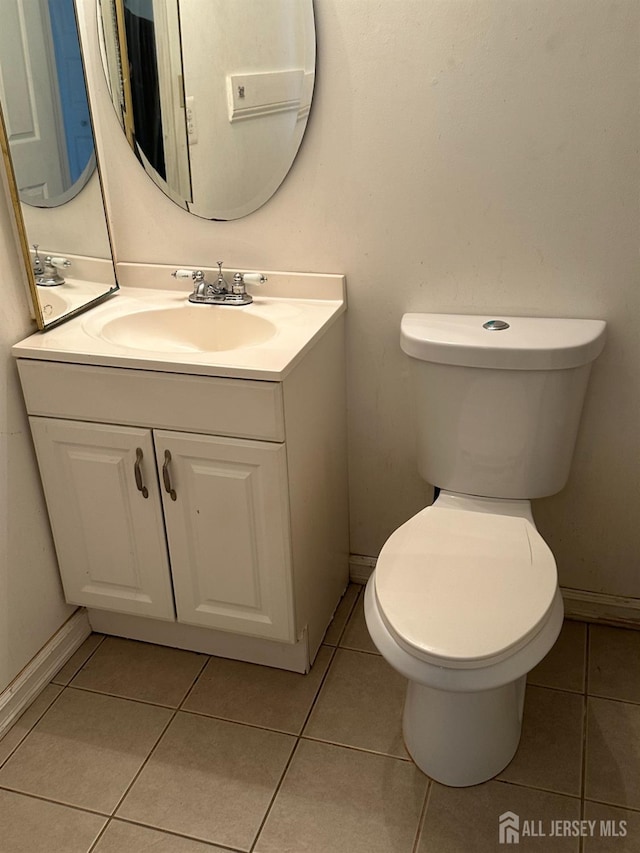 bathroom featuring tile patterned floors, vanity, and toilet