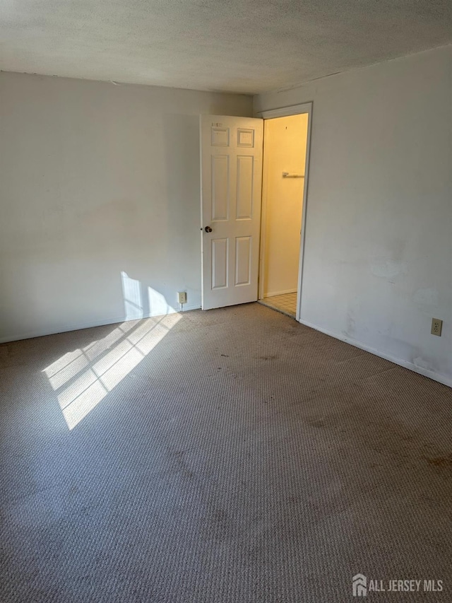 carpeted empty room with a textured ceiling