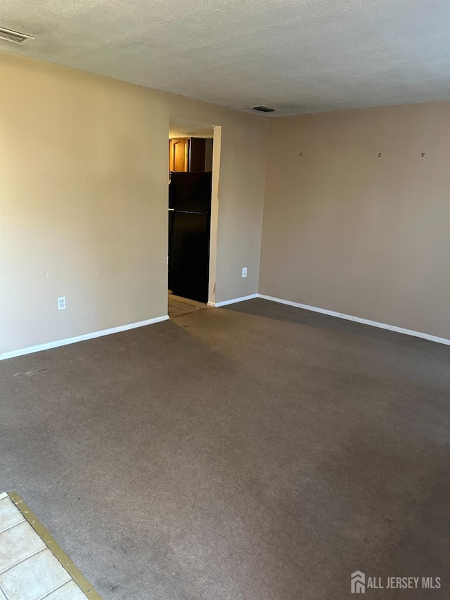 unfurnished living room with carpet floors and a textured ceiling