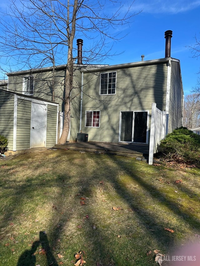 rear view of property with a yard and central AC