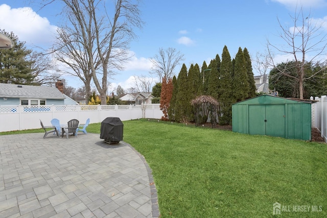 view of yard with a patio area, an outdoor structure, a fenced backyard, and a storage shed