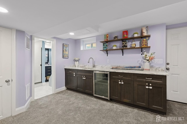 bar featuring wine cooler, indoor wet bar, light colored carpet, visible vents, and a sink