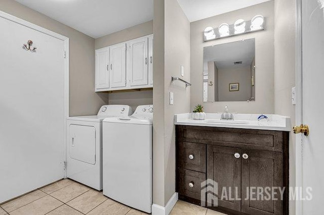 laundry room featuring a sink, cabinet space, light tile patterned floors, and washer and clothes dryer