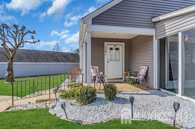 entrance to property featuring a yard and fence