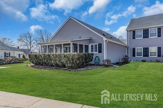 view of front facade with a front lawn and a sunroom