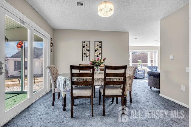 dining space with visible vents, carpet floors, a textured ceiling, and baseboards