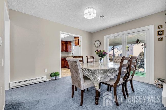 dining area with light colored carpet, visible vents, baseboard heating, and a textured ceiling