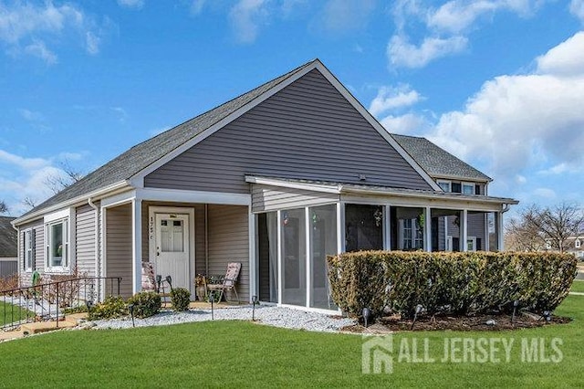 view of front facade with a front lawn and a sunroom