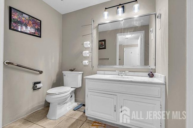 bathroom featuring vanity, tile patterned floors, toilet, and baseboards