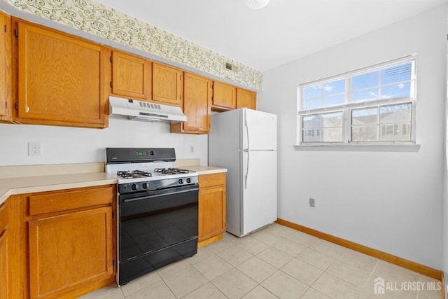 kitchen featuring white refrigerator and gas range oven