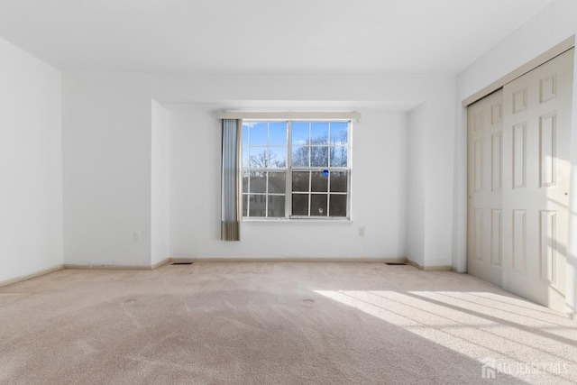 unfurnished bedroom featuring a closet and light carpet