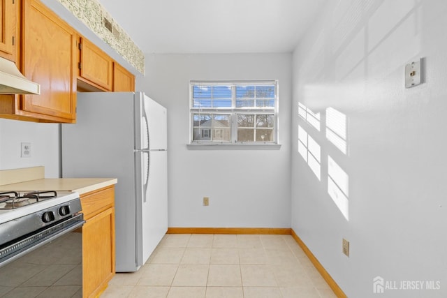 kitchen featuring light tile patterned floors and gas range oven