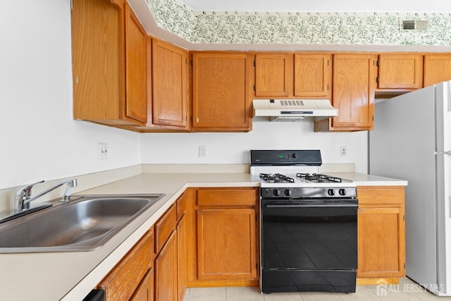 kitchen featuring sink, refrigerator, gas stove, and light tile patterned floors