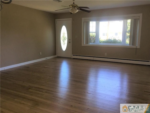 foyer entrance with visible vents, a baseboard heating unit, a ceiling fan, wood finished floors, and baseboards