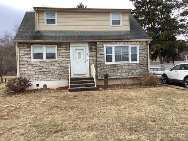 view of front of home featuring entry steps, stone siding, and a shingled roof